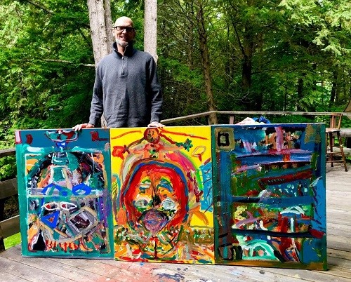 Kevin Whitaker holding his 3 paintings